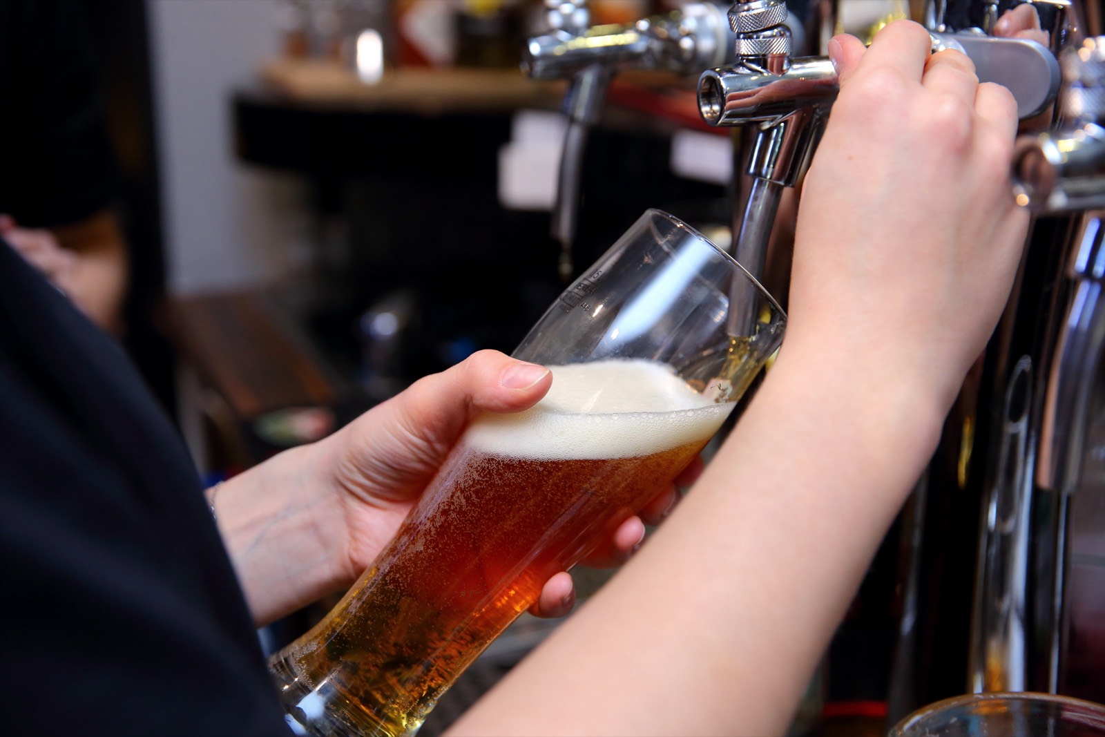 A bartender pouring a craft beer from the tap