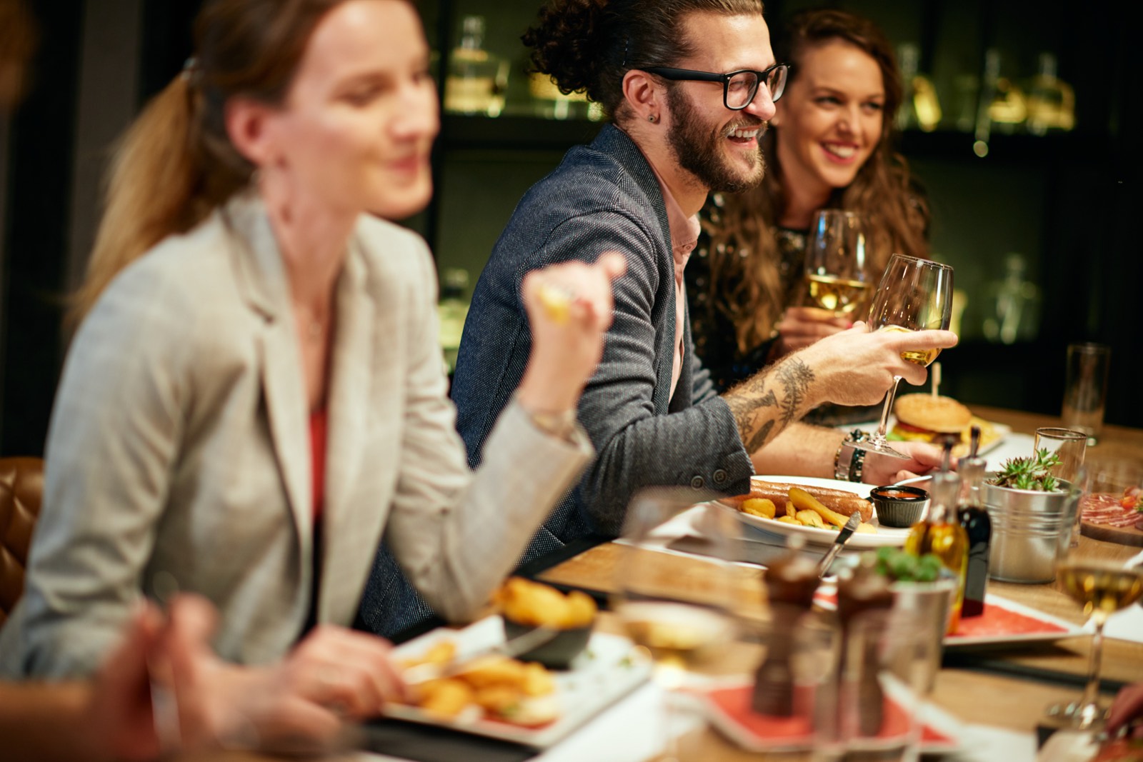 Friends sharing dinner and wine at a restaurant table