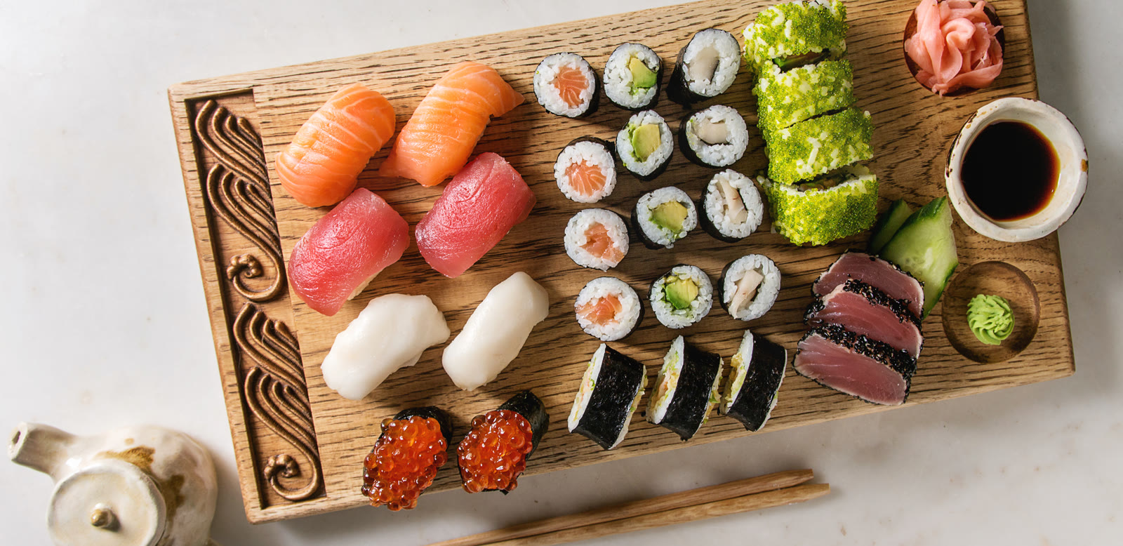 Nigiri and sushi rolls on a wooden serving board