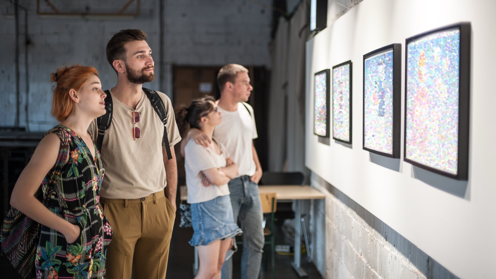 Friends looking at artwork in a modern gallery hall