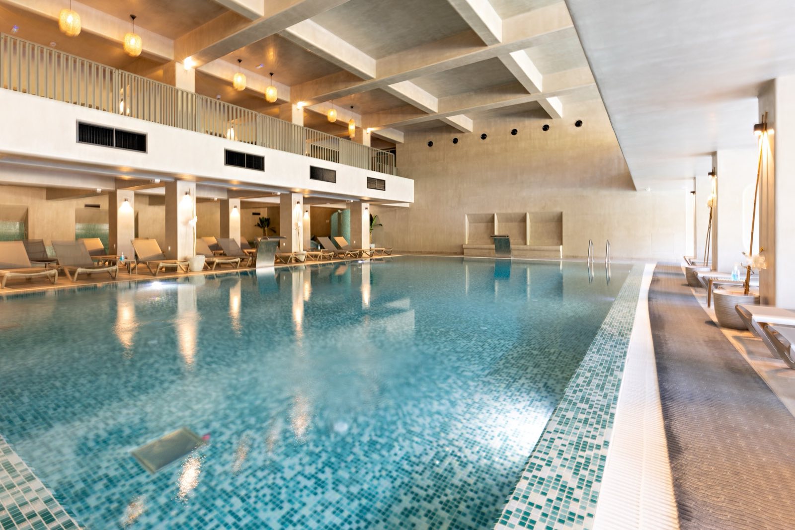 A calm indoor spa pool lined with loungers