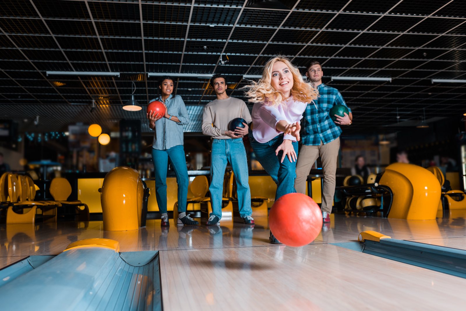 Friends bowling together at an indoor bowling alley