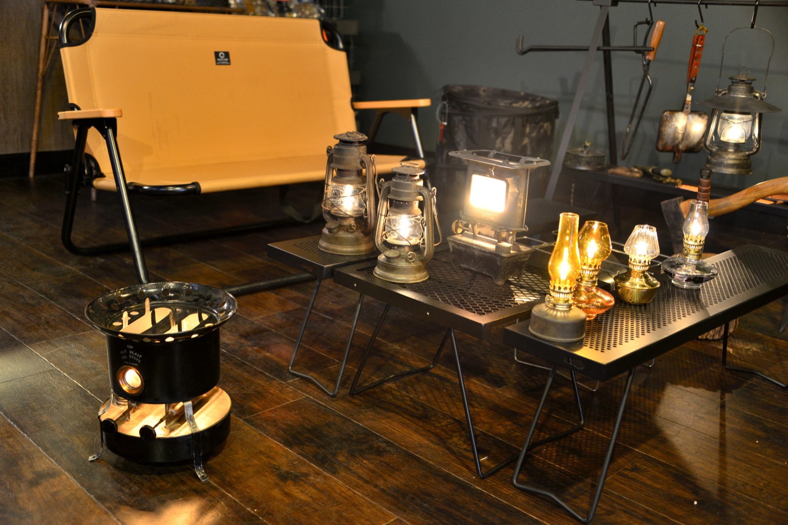 Camp lanterns, a stove and folding tables on display in an outdoor shop