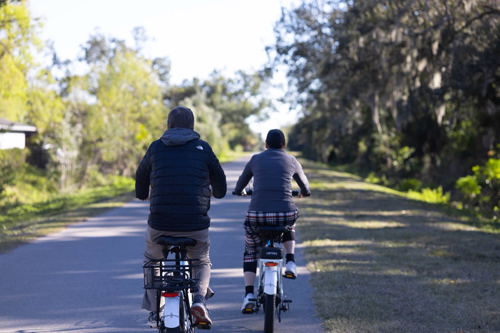 A couple cycling together along a paved trail