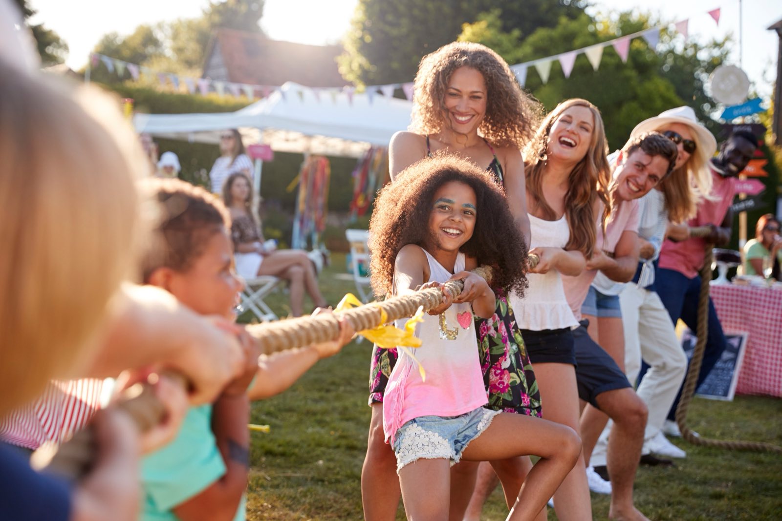 Kids and parents in a tug of war at a summer fair