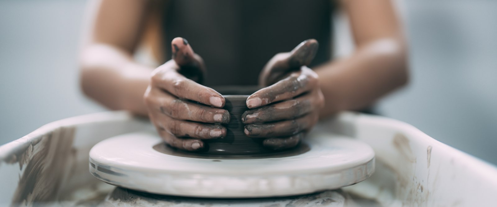 Hands shaping clay on a potter’s wheel